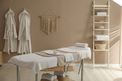 Stylish spa salon interior with massage table