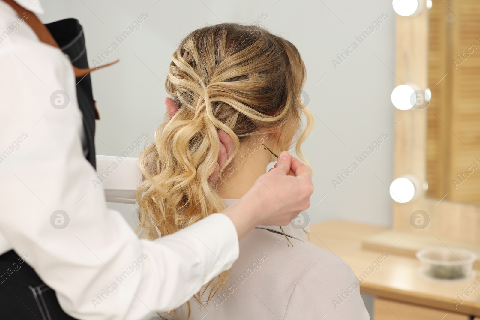 Photo of Hair styling. Professional hairdresser working with client in salon, closeup