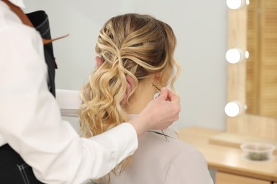 Photo of Hair styling. Professional hairdresser working with client in salon, closeup