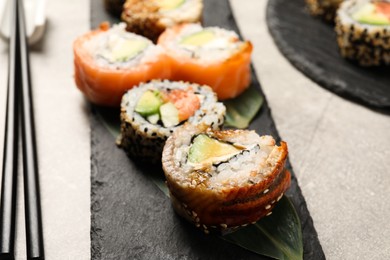 Photo of Delicious sushi rolls on light grey table, closeup
