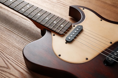 Modern electric guitar on wooden background. Musical instrument