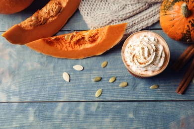 Photo of Flat lay composition with cup of pumpkin spice latte on wooden table