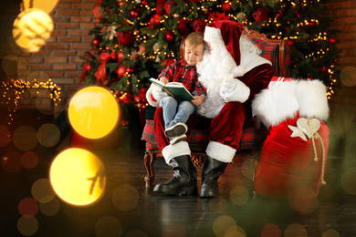 Santa Claus and little boy with book near Christmas tree indoors
