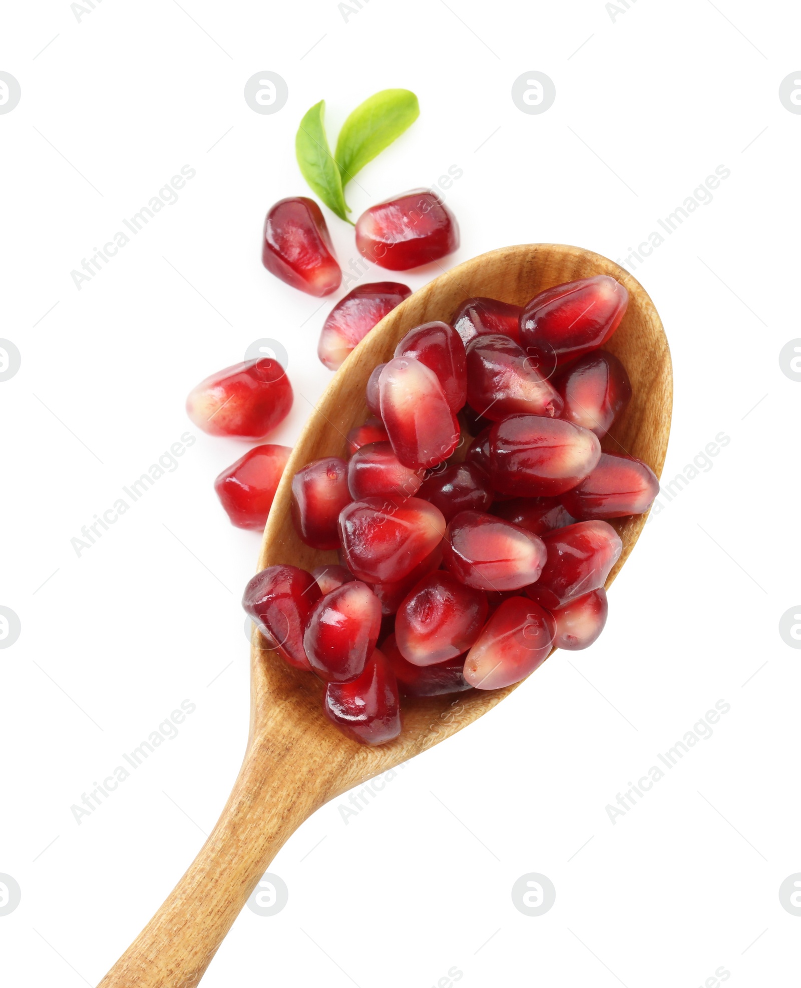 Photo of Ripe juicy pomegranate grains and leaves in wooden spoon isolated on white, top view