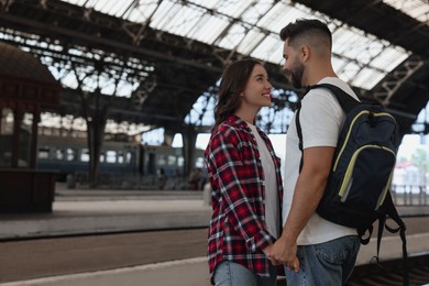 Photo of Long-distance relationship. Beautiful couple on platform of railway station, space for text