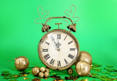 Photo of Vintage alarm clock with Christmas decor on green background. New Year countdown