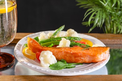 Photo of Healthy meal. Piece of tasty grilled salmon with vegetables on tray, closeup