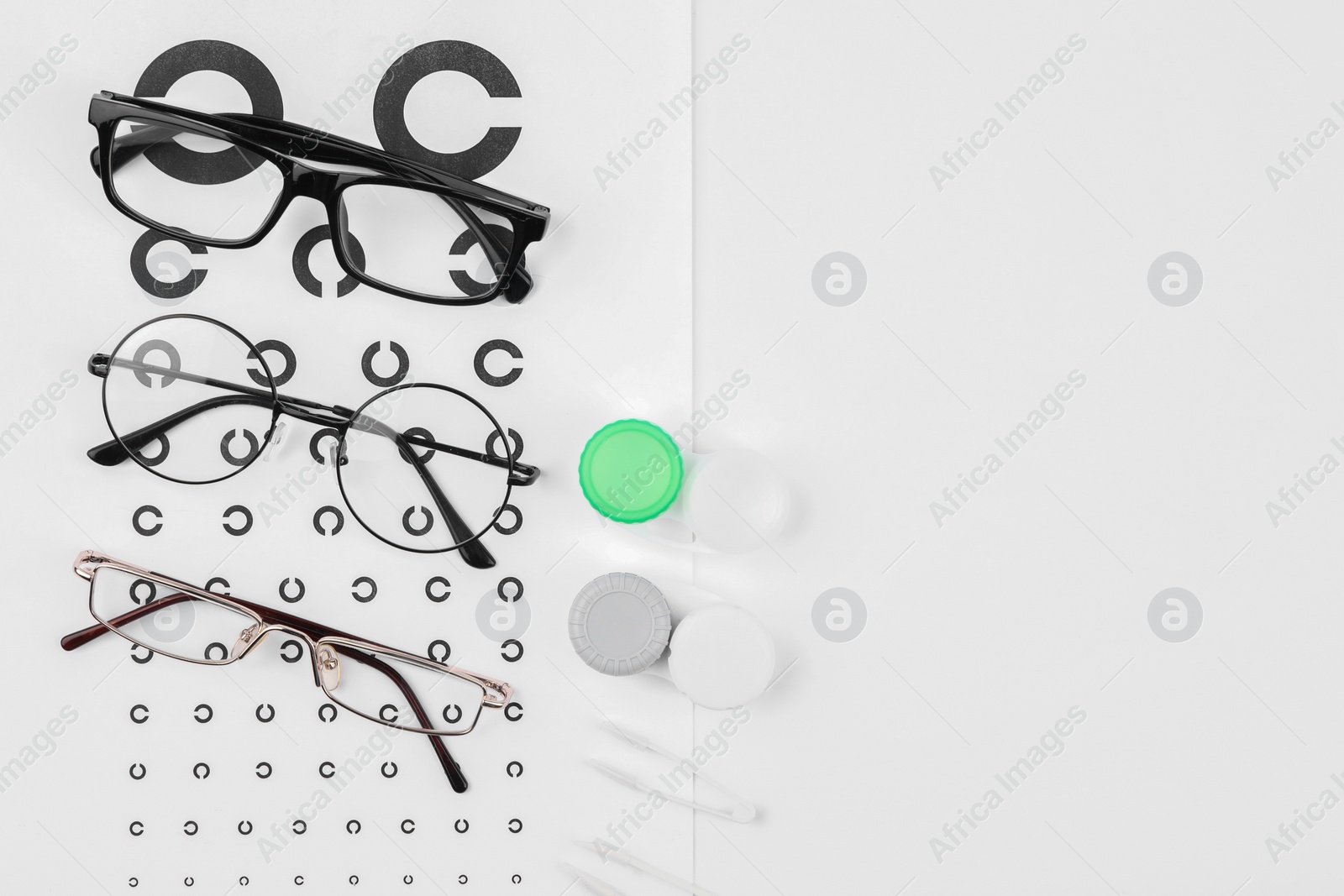 Photo of Vision test chart, glasses, lenses and tweezers on white background, flat lay. Space for text