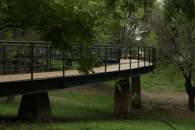 Photo of Beautiful pathway with metal handrails in park near trees