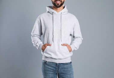 Photo of Young man in sweater on grey background, closeup. Mock up for design