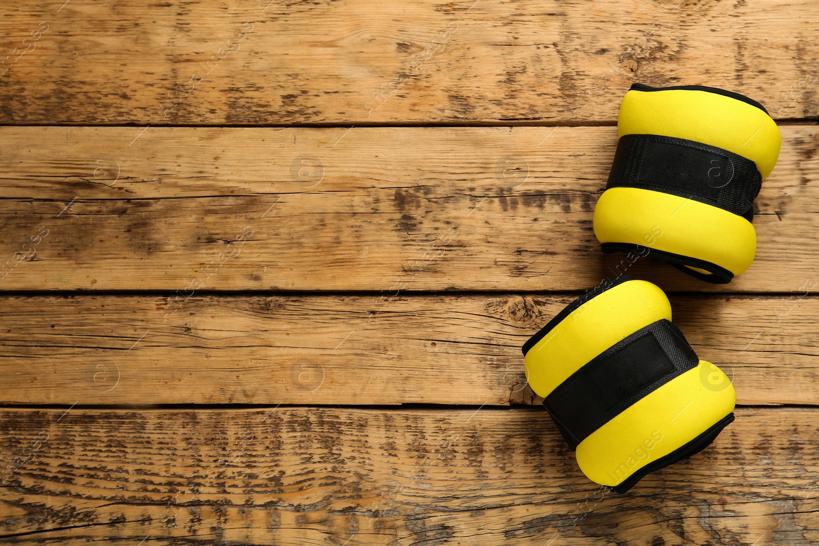 Photo of Yellow weighting agents on wooden table, flat lay. Space for text