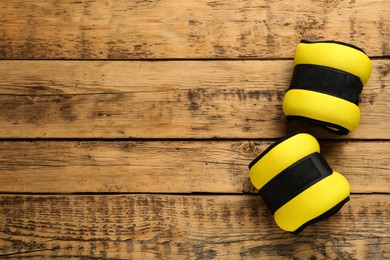 Photo of Yellow weighting agents on wooden table, flat lay. Space for text