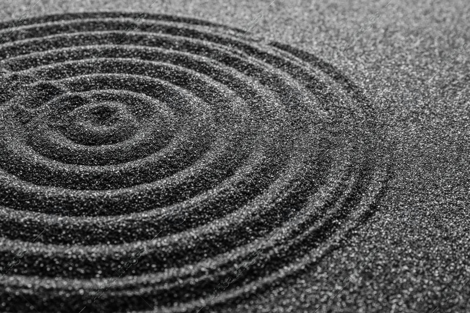 Photo of Black sand with beautiful pattern, closeup. Zen concept