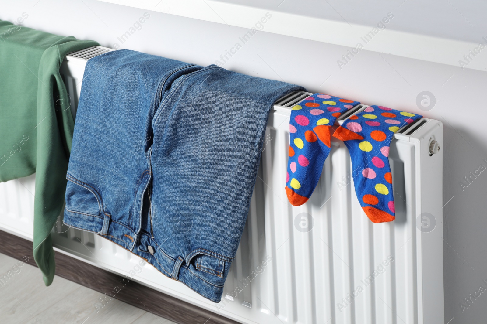 Photo of Clothes hanging on white radiator in room