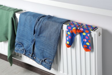 Clothes hanging on white radiator in room