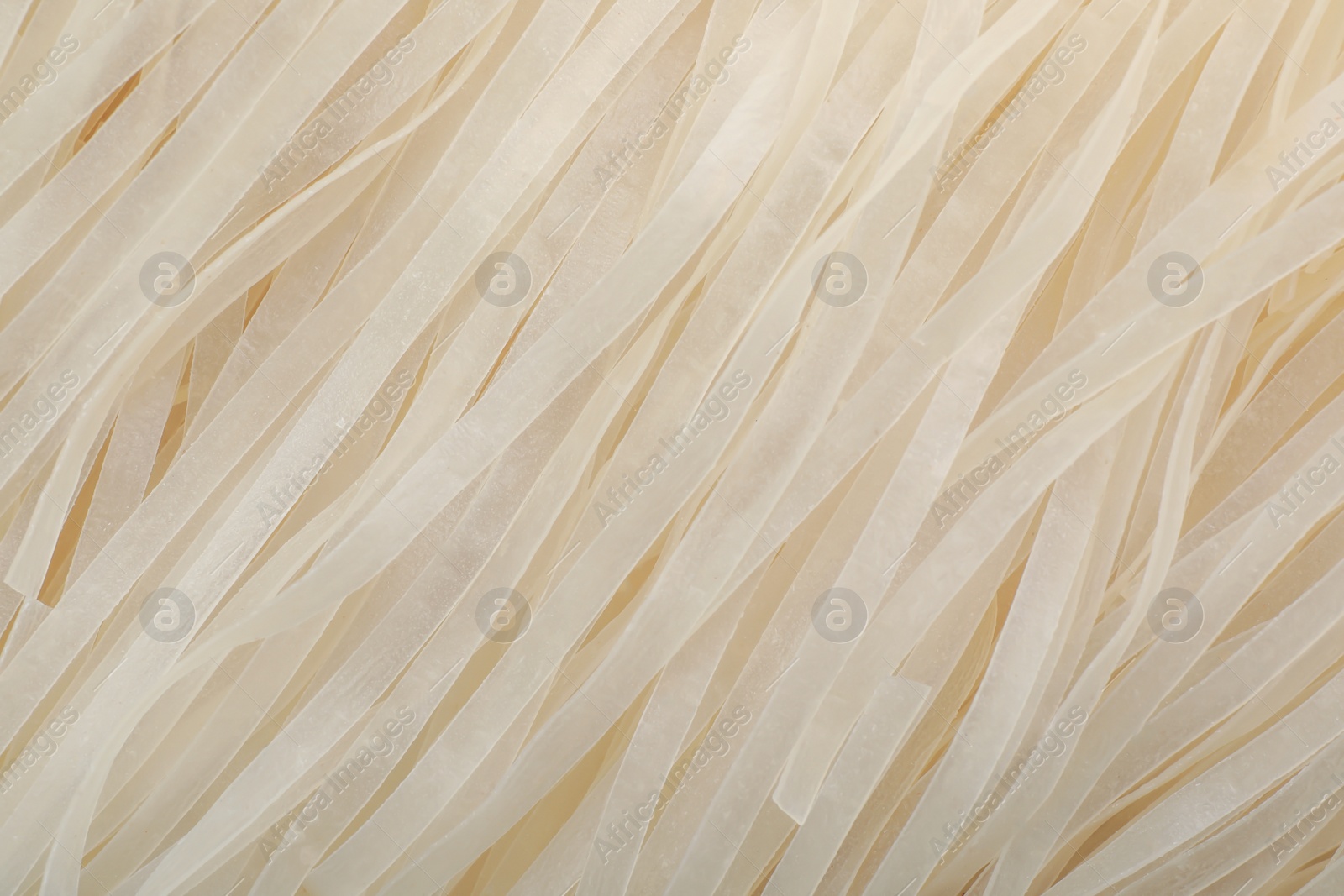 Photo of Raw rice noodles as background, closeup. Delicious pasta