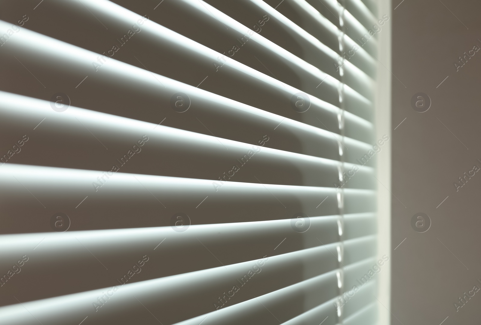 Photo of Closed modern white window blinds, closeup view