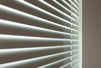 Closed modern white window blinds, closeup view