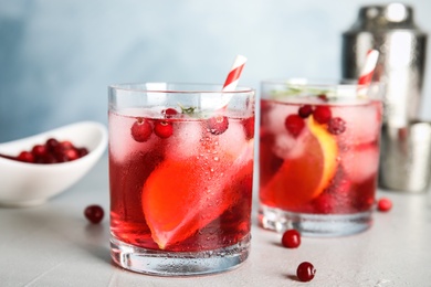 Photo of Tasty refreshing cranberry cocktail on light grey table