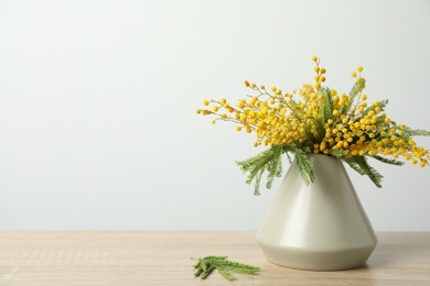 Bouquet of beautiful mimosa flowers on wooden table