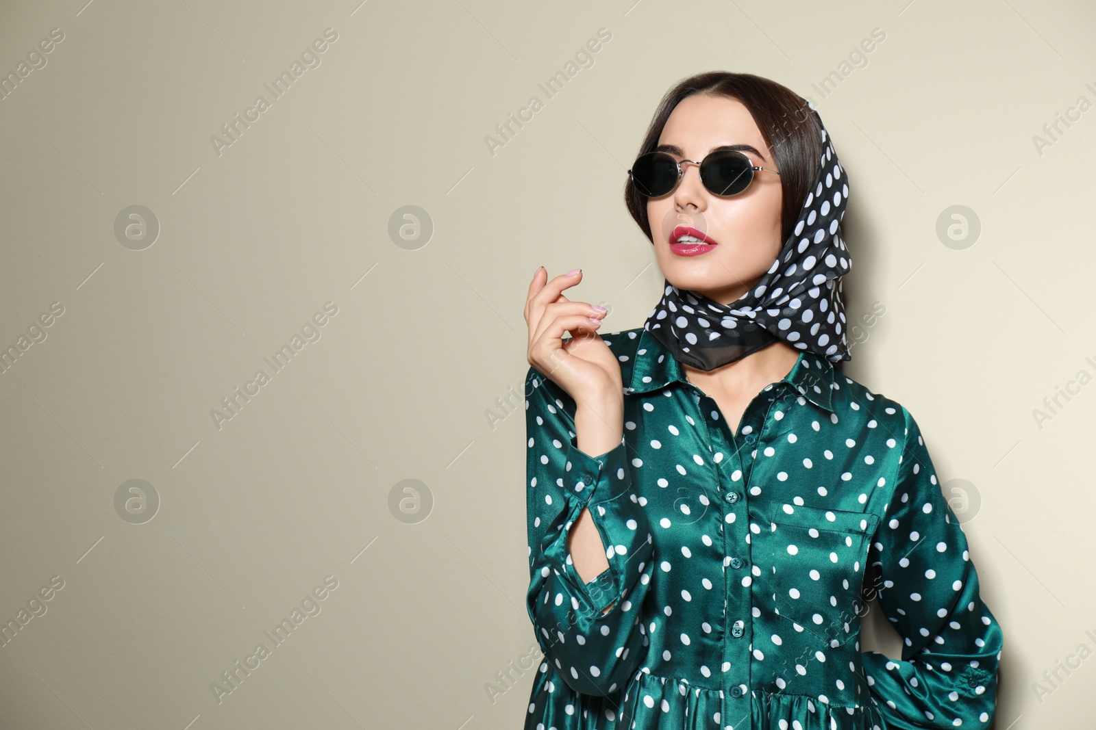 Photo of Beautiful woman in stylish sunglasses on beige background. Space for text