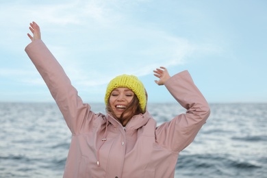 Photo of Stylish young woman spending time near sea