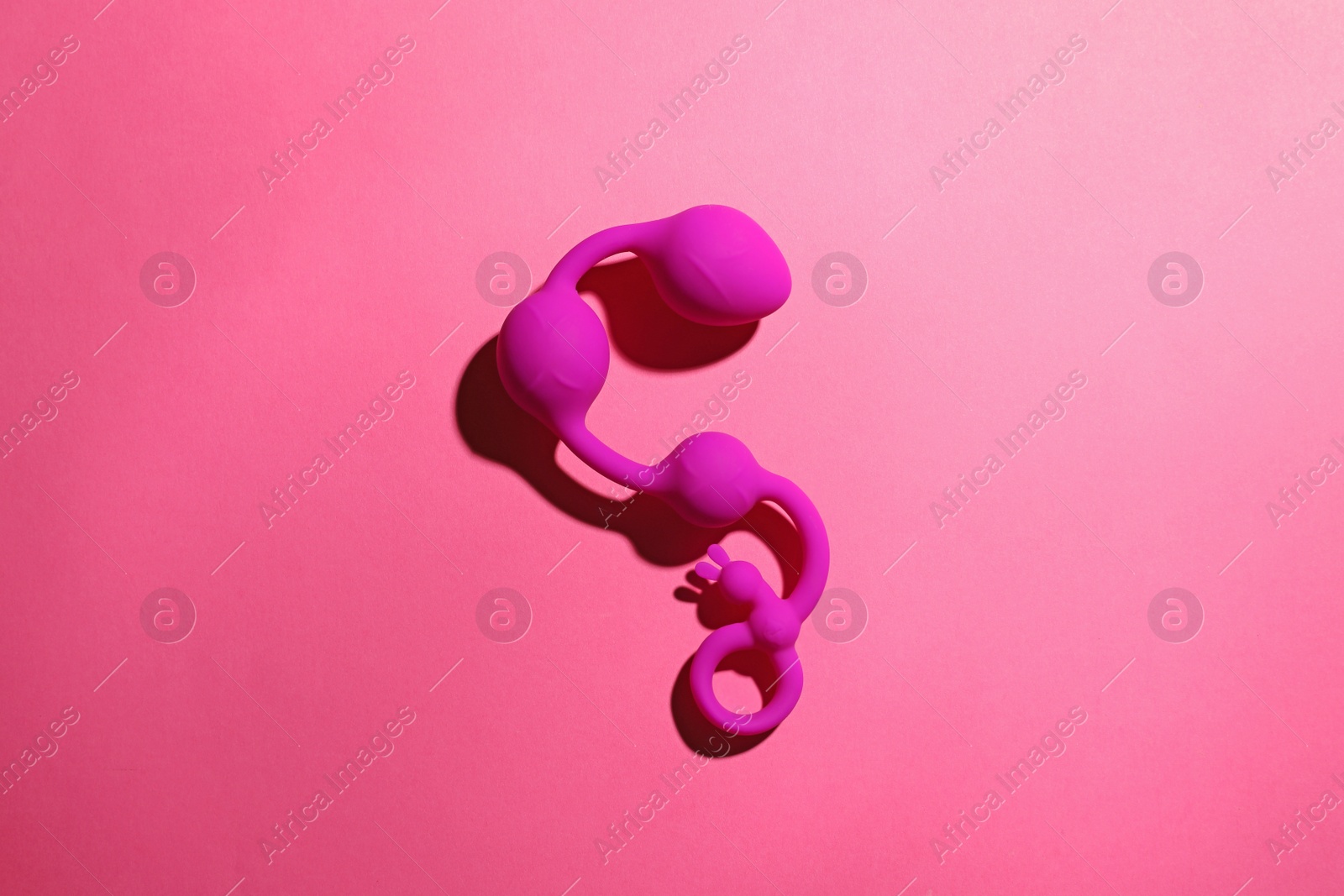 Photo of Anal balls on pink background, top view. Sex toy