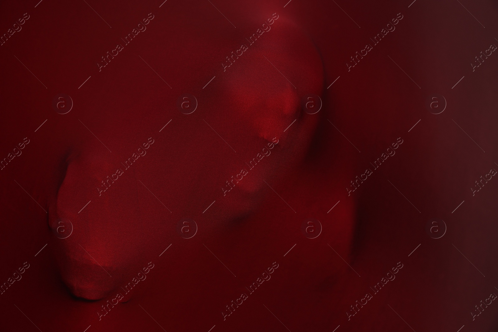 Photo of Silhouette of creepy ghost with skulls behind red cloth