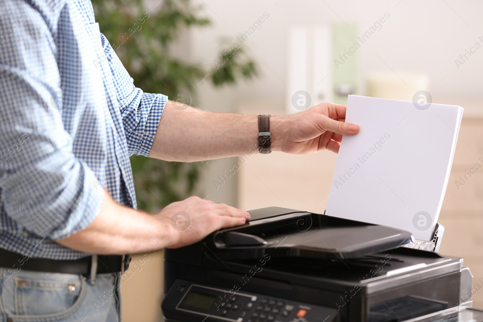 Photo of Employee using modern printer in office, closeup