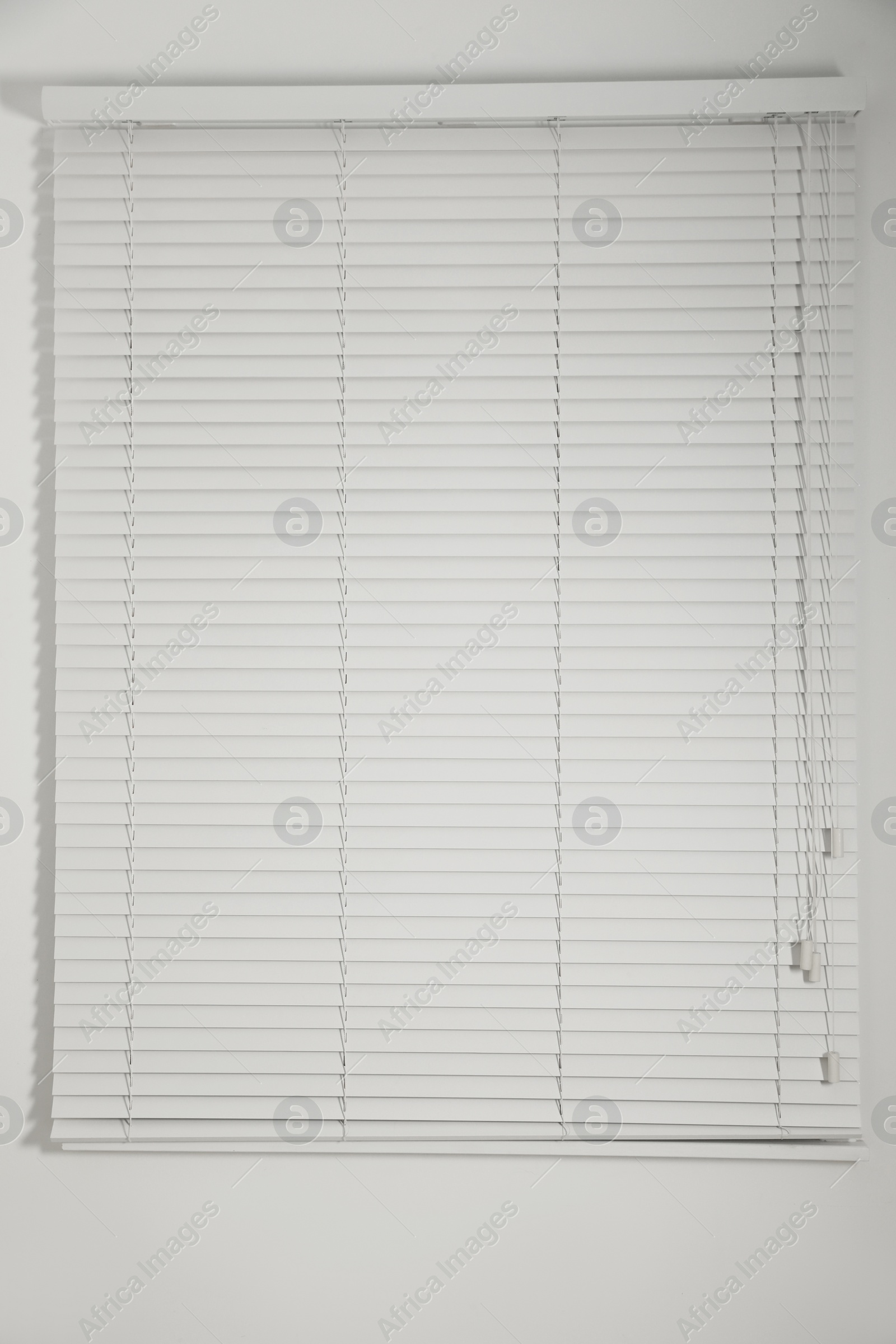 Photo of Window with closed white blinds in room