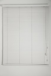 Photo of Window with closed white blinds in room