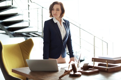 Photo of Female lawyer standing near table in office