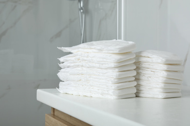 Photo of Stacks of baby diapers on counter in bathroom