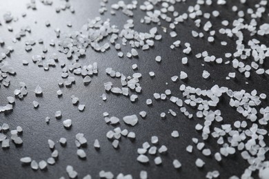 Photo of Scattered white natural salt on black table