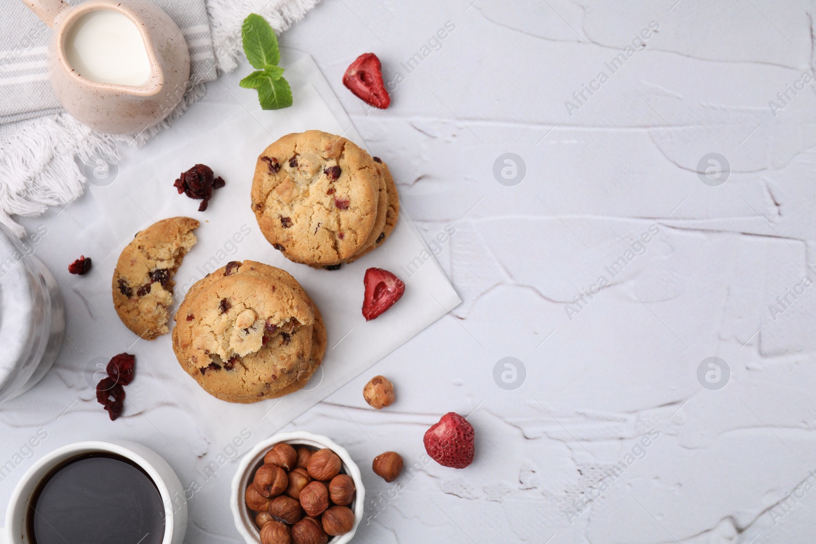 Cookies with freeze dried fruits, mint, milk, coffee and nuts on white textured table, flat lay. Space for text Photo of Cookies with freeze dried fruits, mint, milk, coffee and nuts on white textured table, flat lay. Space for text