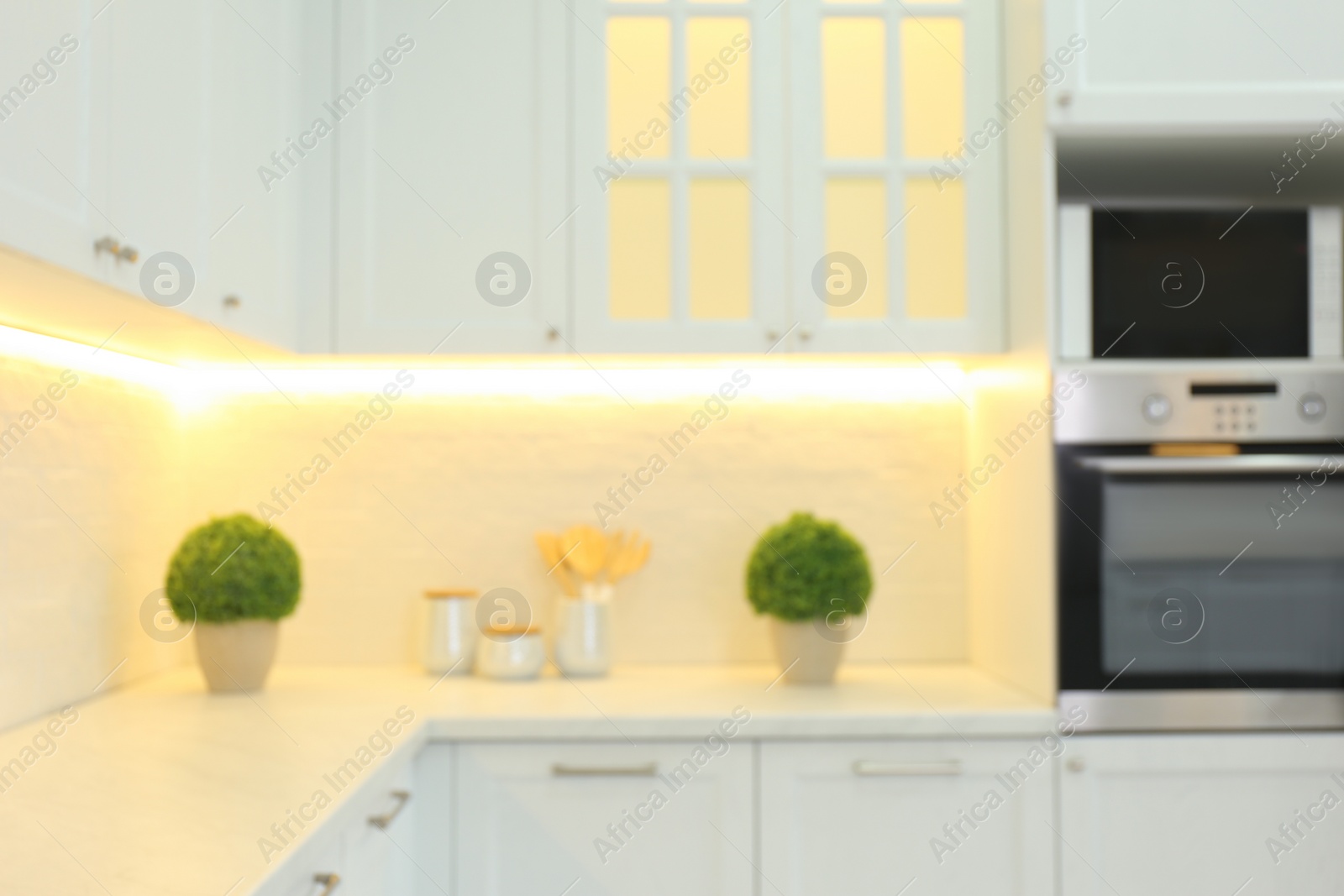 Photo of Blurred view of modern kitchen interior with stylish furniture