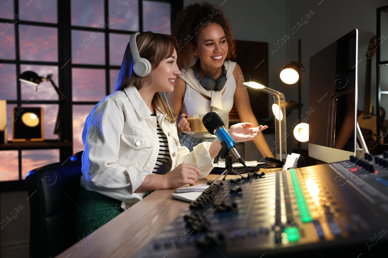 Photo of Young women working in modern radio studio