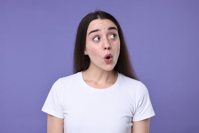 Photo of Portrait of surprised woman on violet background