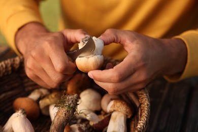 Photo of Man cutting fresh mushroom at table, closeup