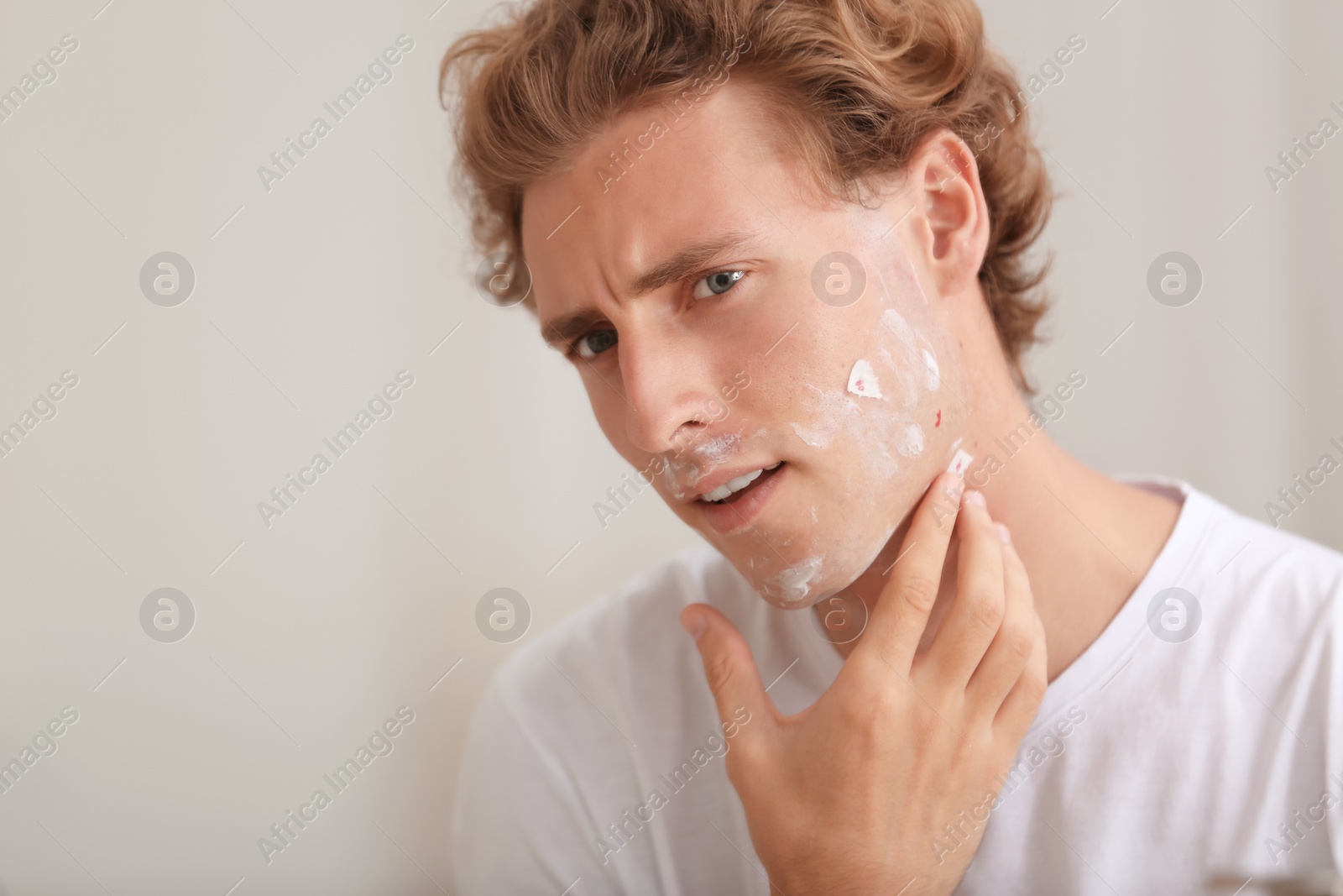 Photo of Young man with face hurt while shaving at home