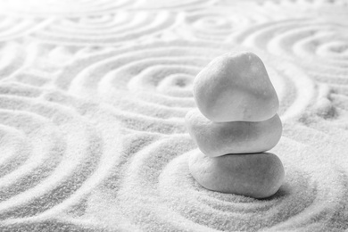 Photo of Stack of white stones on sand with pattern, space for text. Zen, meditation, harmony