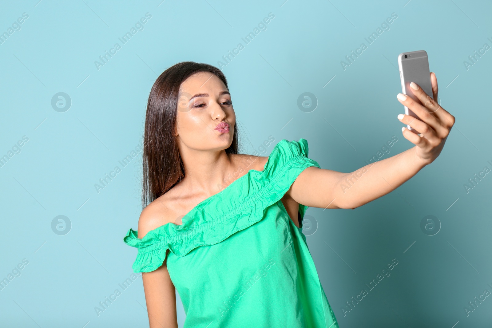 Photo of Young beautiful woman taking selfie against color background