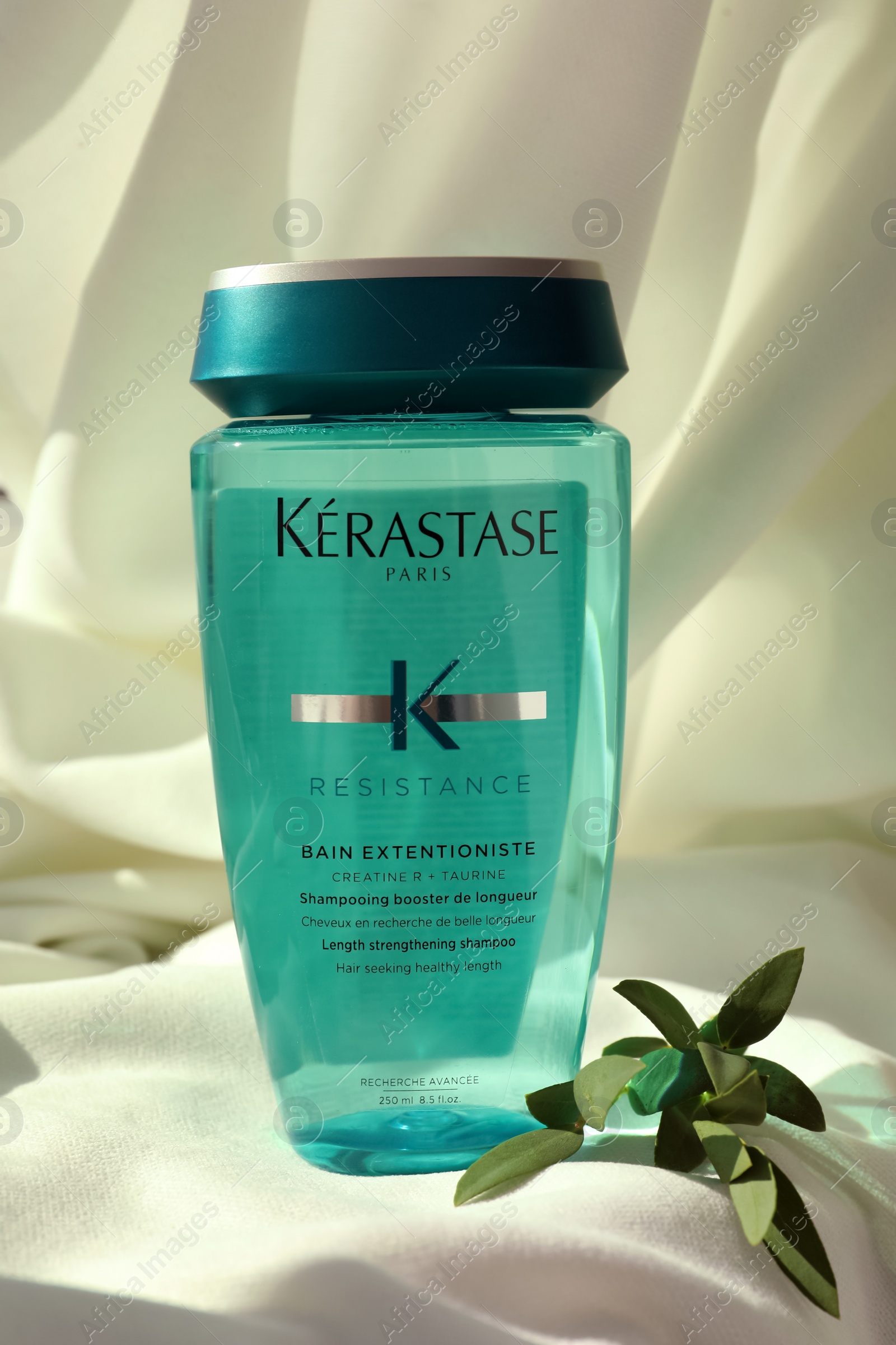 Photo of MYKOLAIV, UKRAINE - SEPTEMBER 07, 2021: Kerastase shampoo on white fabric. Hair care cosmetic product