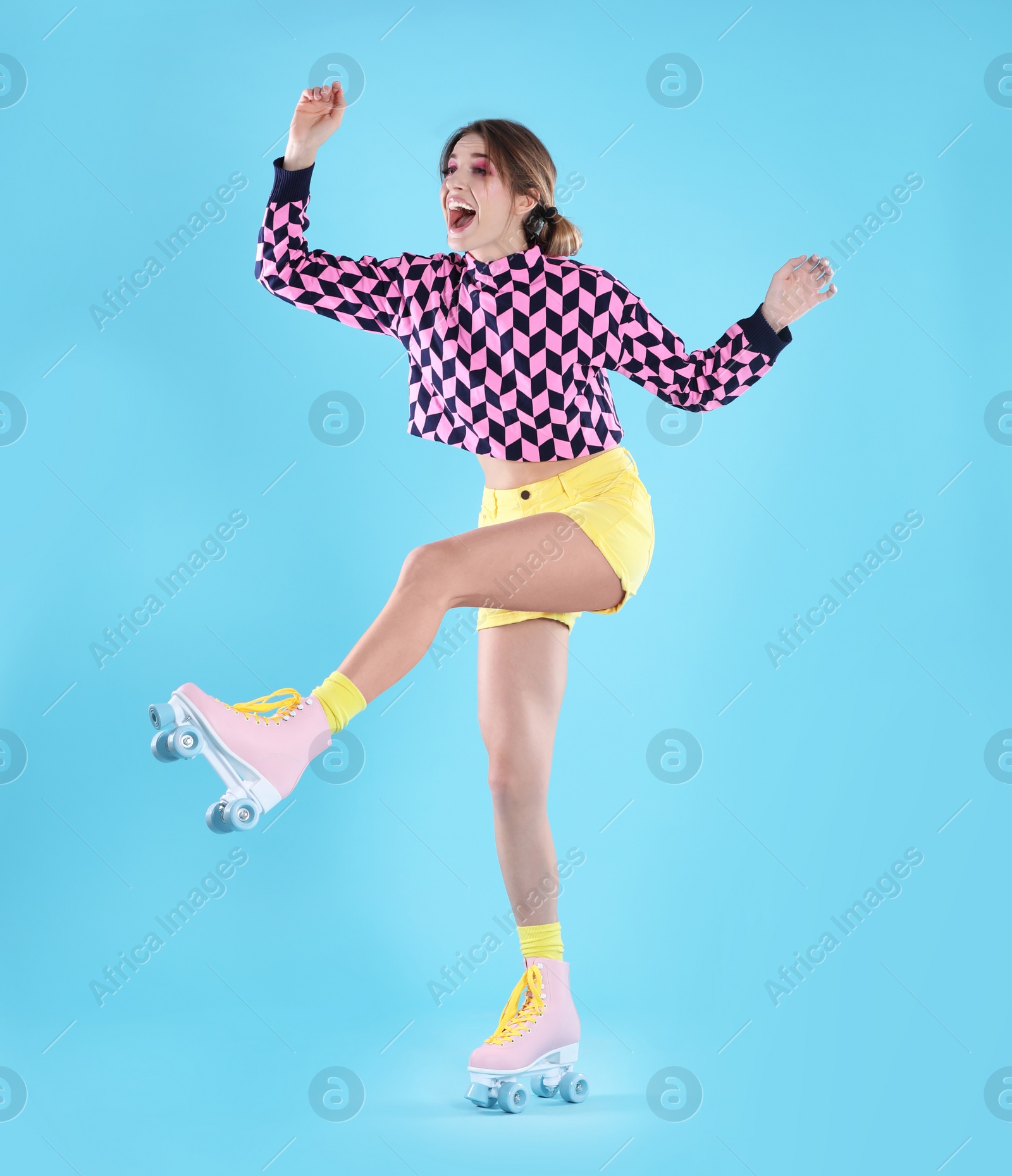 Photo of Young woman with retro roller skates on color background