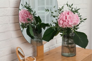 Photo of Beautiful pink hortensia flowers in vase on dressing table indoors
