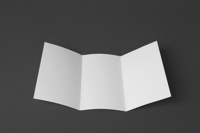 Photo of Blank brochure on dark grey background. Mock up for design