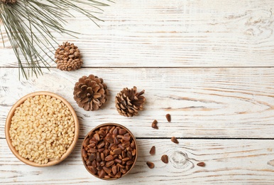 Flat lay composition with pine nuts and space for text on wooden background