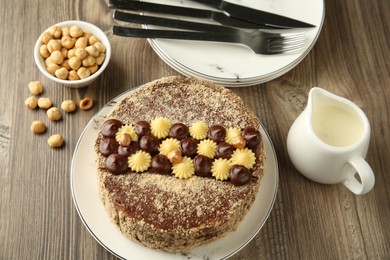 Photo of Delicious Kyiv Cake with cream and hazelnuts served on wooden table