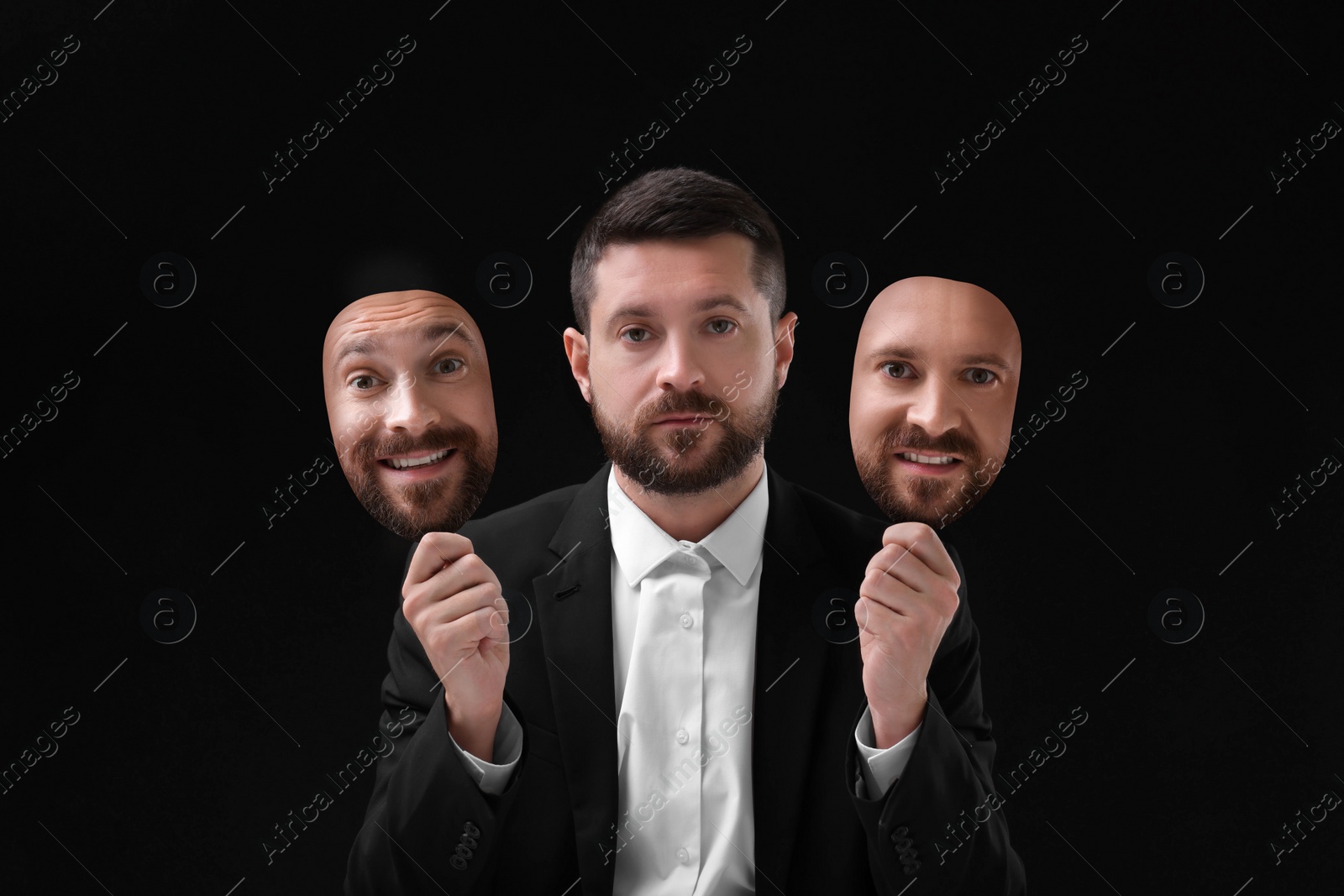 Image of Man holding masks with his face showing different emotions on black background. Balanced personality