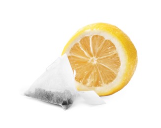 Tea bag and half of lemon on white background
